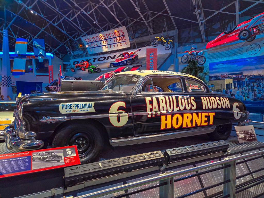 Black NASCAR stock car number 6 with prominent yellow 'Fabulous Hudson Hornet' text