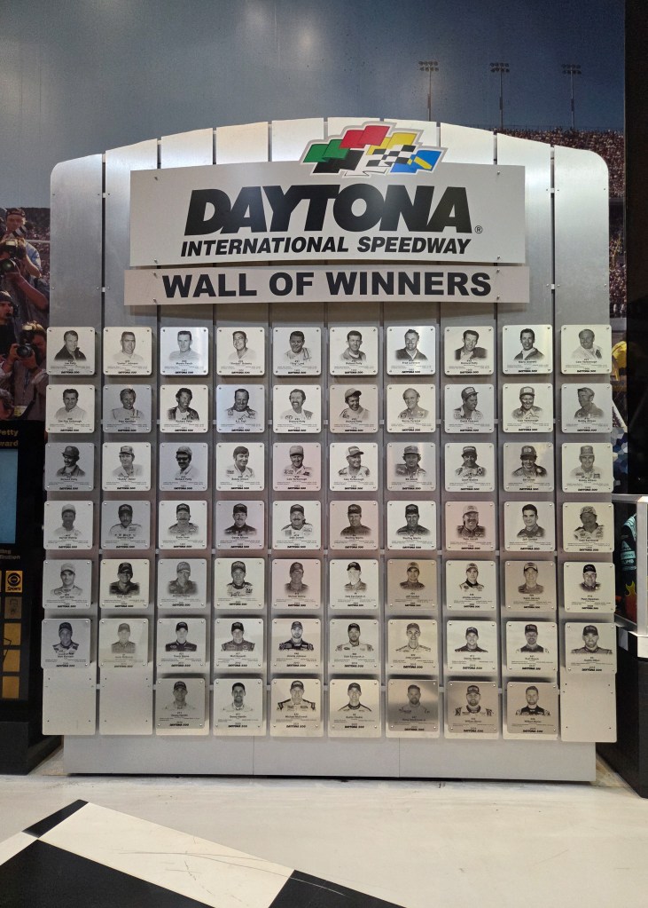 Large Daytona International Speedway 'Wall of Winners' plaque featuring a grid of small portraits and names of past Daytona 500 and other major race winners.